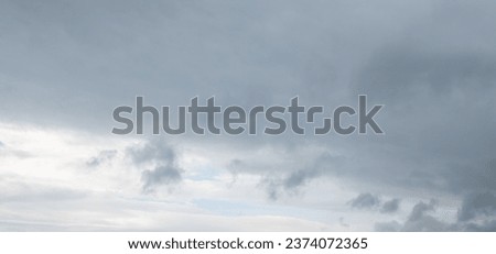 Autumn brings overcast skies adorned with gray stratus clouds, hinting at impending rain. This full-screen view provides ample space for text or design elements, making it perfect for various projects Royalty-Free Stock Photo #2374072365