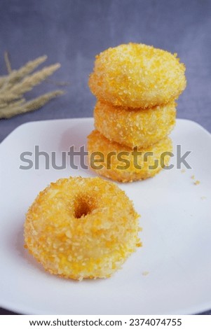 Stack of Donuts with crumbs on the rattan with cement background 