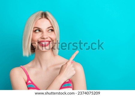 Photo portrait of pretty young girl cheerful look point empty space dressed stylish striped outfit isolated on aquamarine color background