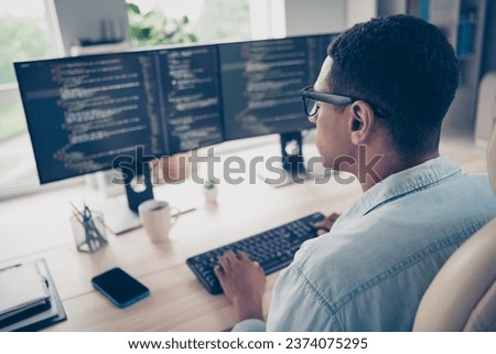 Side profile photo of serious man hardware expert sitting chair keyboard writing open space program system watch monitors in office