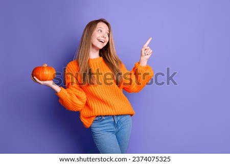 Photo of lovely positive girl arm hold pumpkin look indicate finger empty space isolated on violet color background