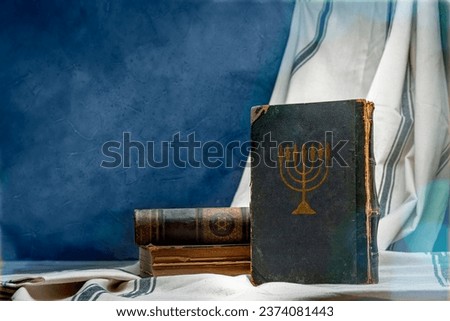 Old book Talmud, Hebrew Rabbinic Judaism, Jewish religious law. Torah, Hebrew Bible. Menorah on a dark cover. Holy Scripture containing the word of God. Antique edition, vintage worn paper. Royalty-Free Stock Photo #2374081443