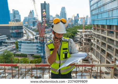 architect engineer designing a structure holding tablet, walkie talkie, drawing