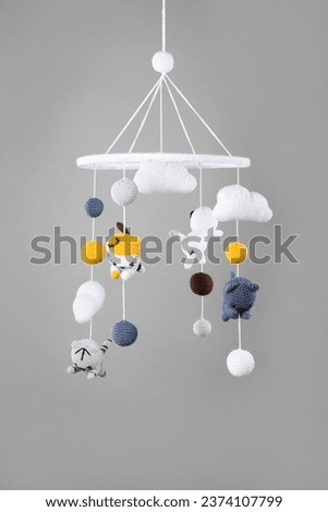 Cute baby crib mobile on grey background