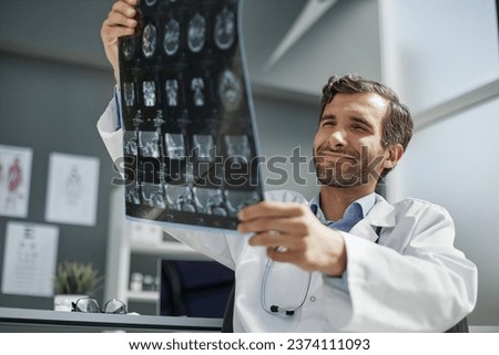 Doctor looking at x ray picture of head.