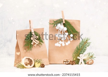 Christmas holiday gift bags for suprise, fir branches, gingerbread man, elk, snow covered berries and nuts, blank tag with copy space 