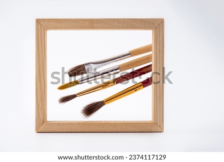 light wooden framed mockup picture of some watercolor sable brushes with wooden handles