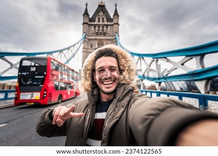 Smiling man taking selfie picture in London, England - Young tourist male taking memory pic with iconic england landmark - Weekend holidays concept