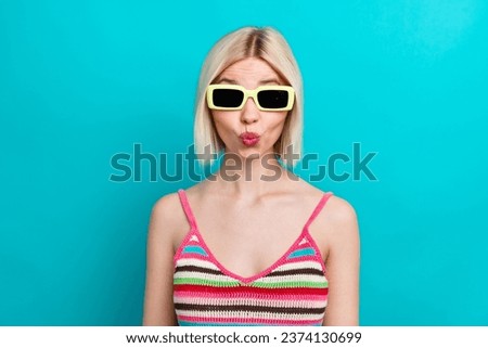 Portrait of pouty lips funny playful girl flirting humorous wear sunglasses with trendy striped singlet isolated on blue color background