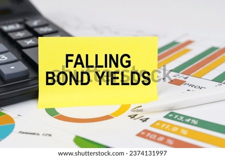 Business concept. On business reports there is a calculator and a sign with the inscription - falling bond yields