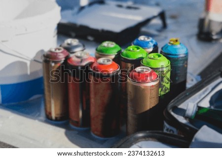 Equipment set for street art, spray cans bottles with aerosol spray paint, creating graffiti and mural on the walls, with paint can, brush, roller, street artist kit for stencil murals and grafiti Royalty-Free Stock Photo #2374132613