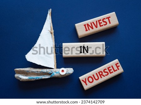 Invest in Yourself symbol. Concept words Invest in Yourself on wooden blocks. Beautiful deep blue background with boat. Business and Invest in Yourself concept. Copy space.
