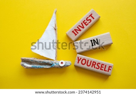 Invest in Yourself symbol. Concept words Invest in Yourself on wooden blocks. Beautiful yellow background with boat. Business and Invest in Yourself concept. Copy space.