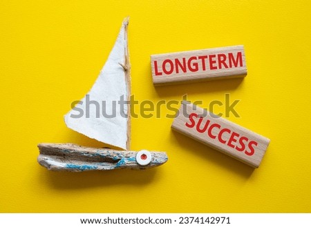 Longterm success symbol. Wooden blocks with words Longterm success. Beautiful yellow background with boat. Business and Longterm success concept. Copy space.