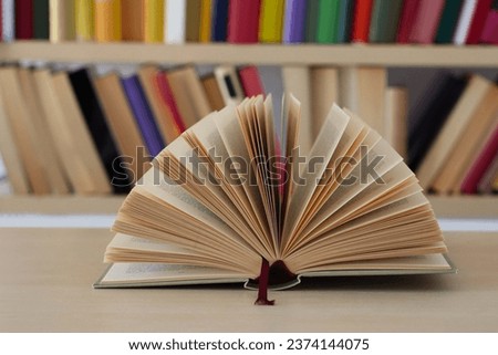open book and hardback books on wooden table background. back to school. copy space