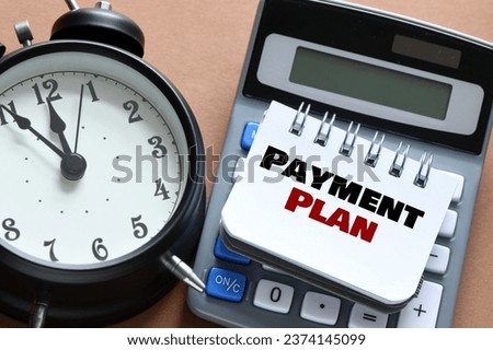 PAYMENT PLAN text on an open notepad on the table.  Royalty-Free Stock Photo #2374145099