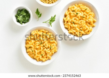 Macaroni and cheese in bowl over white background. Top view, flat lay Royalty-Free Stock Photo #2374152463