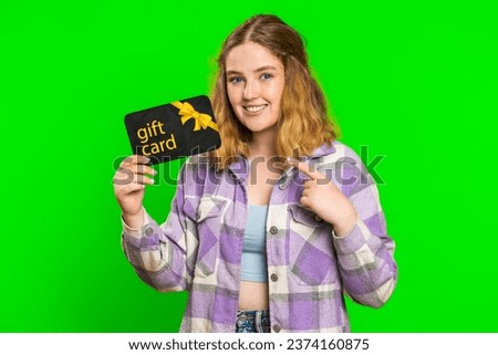 Happy caucasian woman showing pointing on gift discount certificate voucher coupon for store holidays sale. Redhead girl with shopping christmas surprise card isolated on green chroma key background