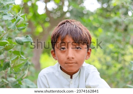 A Pakistani baby boy stylish posing against mangoes field. Pakistani model baby boy doing stylish poses. Pakistani village baby boy in cultural dress. Portrait of Asian model baby boy. Happy face.