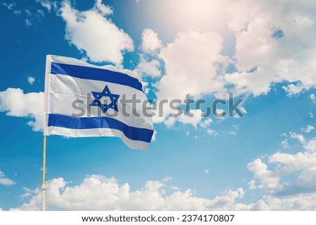 Israel flag with a star of David over beautiful sky background Royalty-Free Stock Photo #2374170807