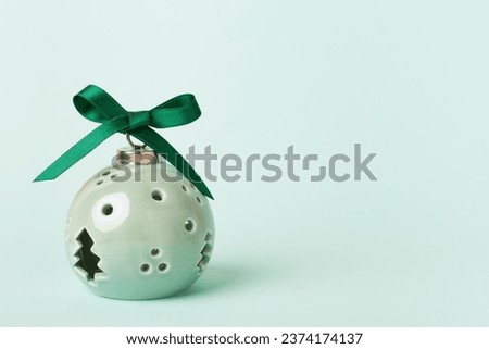 Lamp in Christmas bauble shape on color background