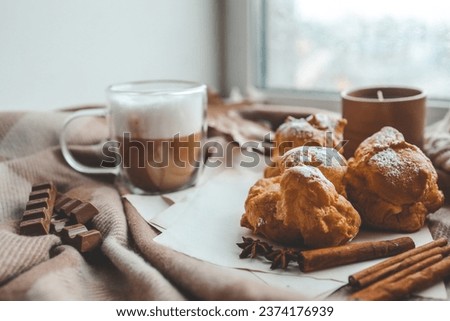 Cozy morning composition, cup of coffee, custard cakes and candle.