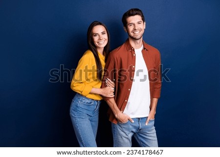 Portrait of two idyllic positive partners beaming smile good mood hold arm isolated on dark blue color background