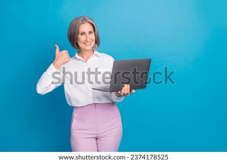 Photo of shiny confident lady wear white shirt typing email modern gadget thumb up empty space isolated blue color background