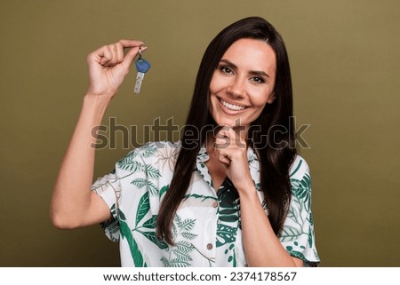 Photo of lovely nice woman with straight hair wear stylish shirt hand demonstrate keys finger on chin isolated on brown color background
