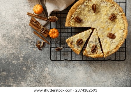 Thanksgiving dessert. Fall traditional pie pumpkin with crumble and pecan on a gray stone background. View from above. Copy space. 