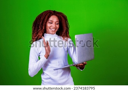 Smiling cheerful beautiful attractive young brunette 20s working on laptop computer isolated on green color background studio portrait