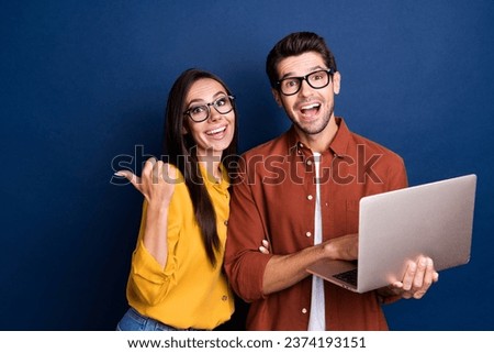Portrait of two astonished crazy people use netbook direct finger empty space information isolated on blue color background