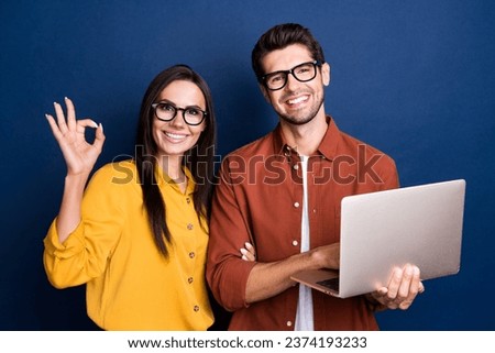 Portrait of two businesspeople use netbook demonstrate okey approve symbol isolated on blue color background Royalty-Free Stock Photo #2374193233