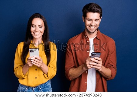 Portrait of cheerful people beaming smile use apple iphone gadget chatting typing post isolated on blue color background