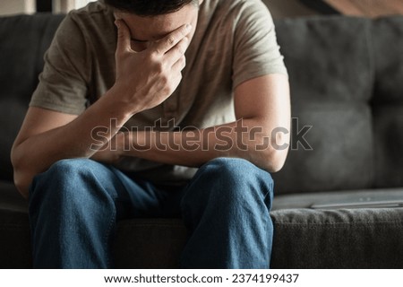 Young man with head down suffering from loneliness, depression, stress, feeling overwhelmed.  Royalty-Free Stock Photo #2374199437
