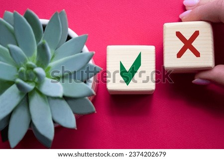 Yes vs No symbol. Businessman hand is making a choice between YES and No symbol. Beautiful red background with succulent plant. Business concept. Copy space.