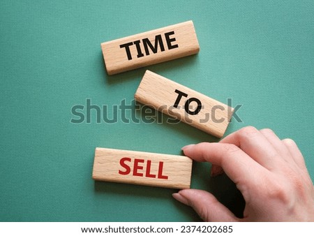 Time to Sell symbol. Concept words Time to Sell on wooden blocks. Businessman hand. Beautiful grey green background. Business and Time to Sell concept. Copy space.