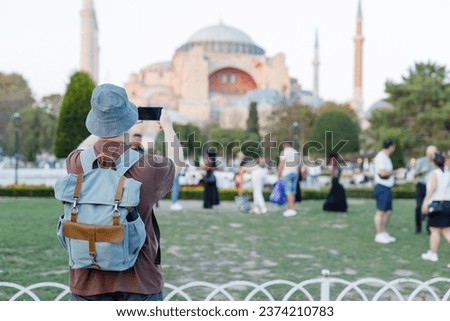tourist takes photos of the mosque on his phone