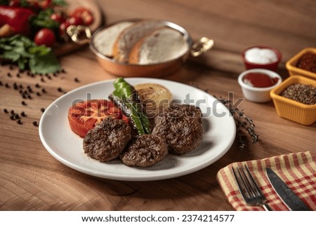 Meatball plate,
Roasted peppers, Roasted tomatoes, Roasted onions and meatballs plate, Barbecued meatballs,
Meatball plate on wooden table, grilled meatballs, Delicious composition Royalty-Free Stock Photo #2374214577