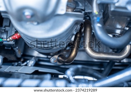 Blurry picture of hybrid automotive industry part of modern new car engine room, Machine show all parts and open hood. Engine and electric motor room of new car.