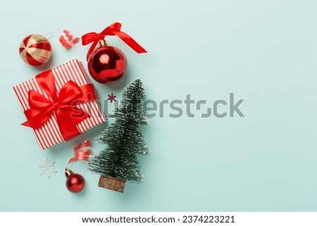 Miniature christmas tree with gift box and decor on color background