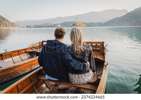 A couple of lovers are sitting on a boat and having a passionate moment of love. Royalty-Free Stock Photo #2374224665