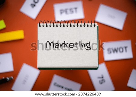 There is notebook with the word Marketing. It is as an eye-catching image.