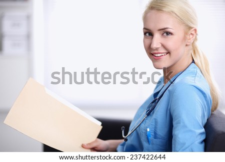 Portrait of a happy young doctor sitting on the sofa with folder