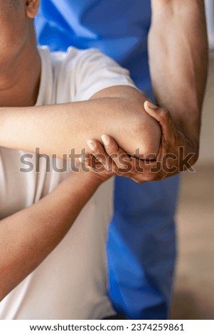 Physical therapist working on the treatment of the injured arm of an Asian male athlete patient. Stretch and exercise Perform pain rehabilitation therapy in the medical clinic. Royalty-Free Stock Photo #2374259861