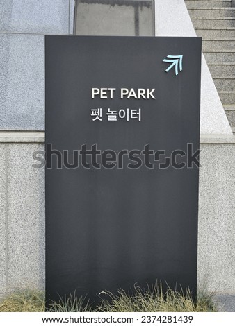 english and korean written pet park sign on the black panel