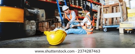 A female warehouse worker has an accident while working in a factory. Royalty-Free Stock Photo #2374287463