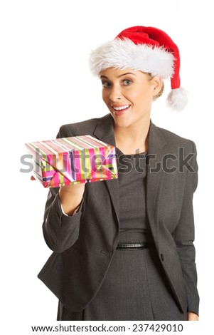 Woman weating Santa hat and holding a present.