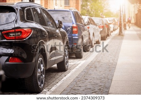 Car Parking Problem in City Street. Many Cars Parked Along Roadside. Modern Parking Problem in Cities Europe. Sun Light. Copy Space. Royalty-Free Stock Photo #2374309373