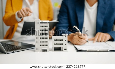 Real estate broker agent presenting and consult to customer to decision making sign insurance form agreement, home model, concerning mortgage loan offer in office
 Royalty-Free Stock Photo #2374318777